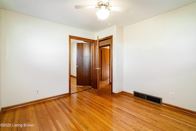 unfurnished bedroom featuring light wood finished floors, baseboards, visible vents, and a ceiling fan