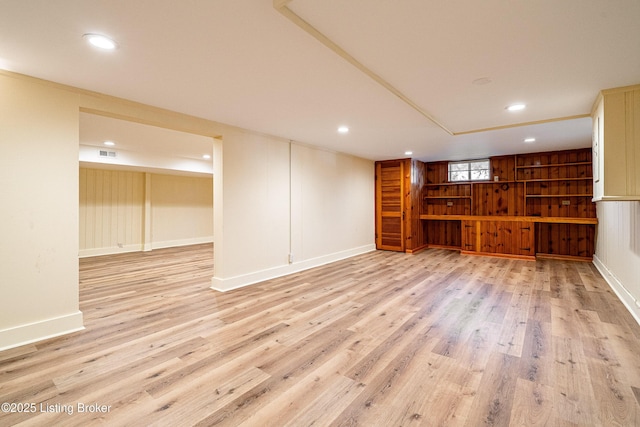 below grade area with light wood-style flooring, visible vents, baseboards, and recessed lighting