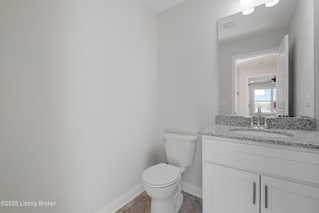 bathroom featuring baseboards, visible vents, vanity, and toilet