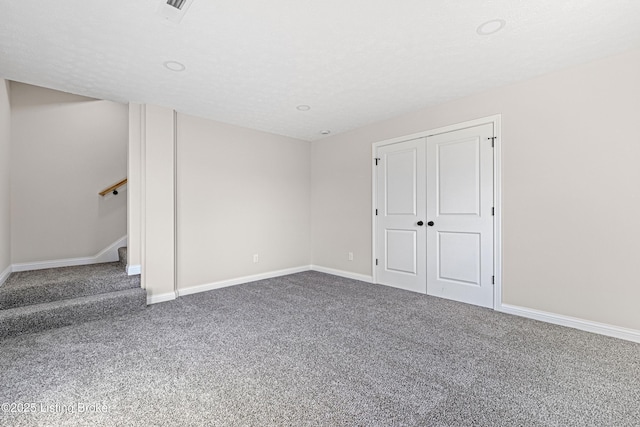 interior space featuring visible vents, baseboards, stairs, a textured ceiling, and carpet floors