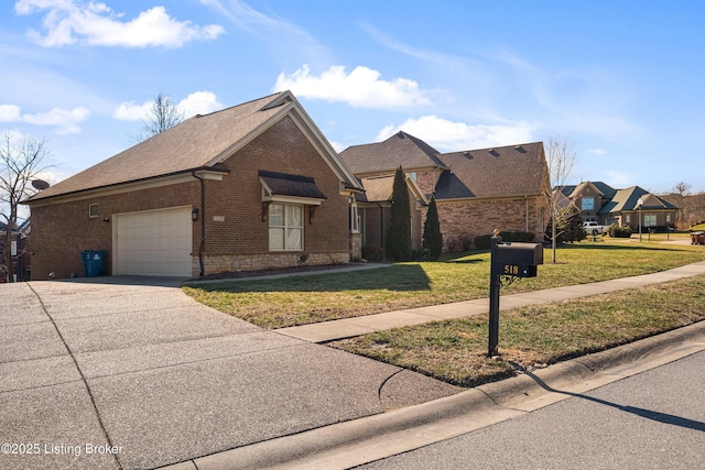 view of front of home featuring driveway, a garage, a front lawn, and brick siding