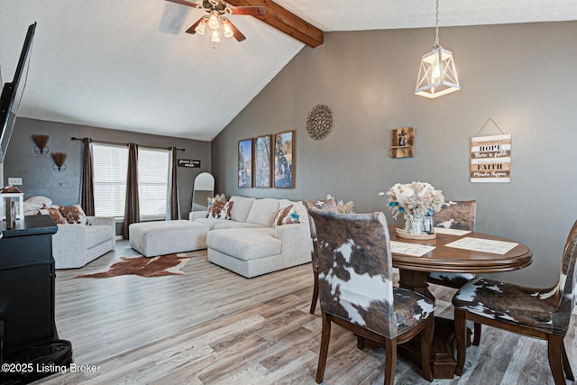 dining room with light wood-type flooring, ceiling fan, and lofted ceiling with beams