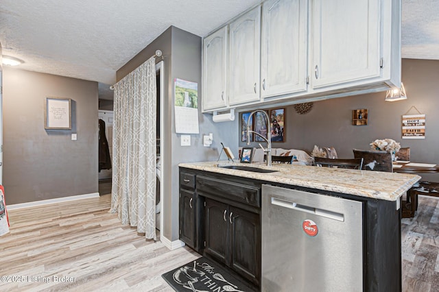 kitchen featuring light wood-style flooring, stainless steel dishwasher, white cabinetry, a sink, and a textured ceiling