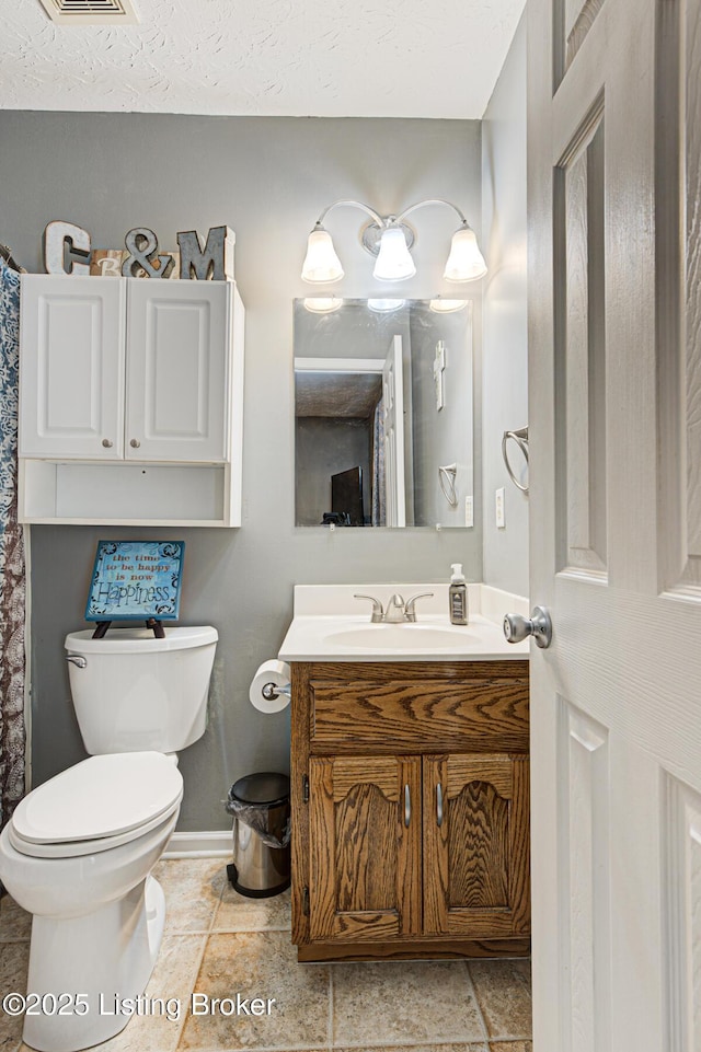 bathroom with baseboards, vanity, toilet, and tile patterned floors