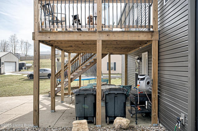 view of patio featuring a garage, stairway, and a wooden deck