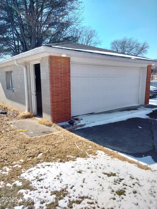 snow covered garage featuring a detached garage