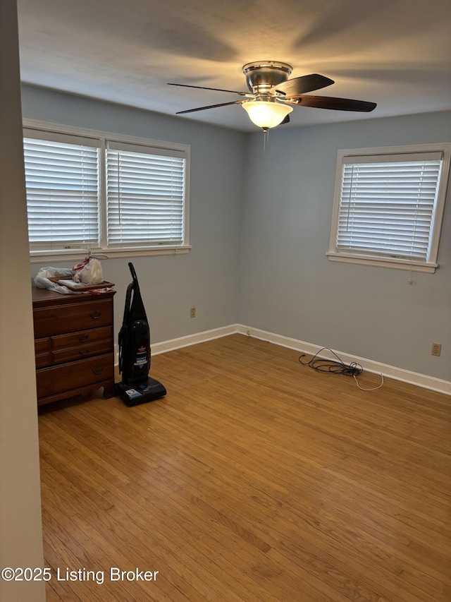 bedroom featuring wood finished floors, a ceiling fan, and baseboards