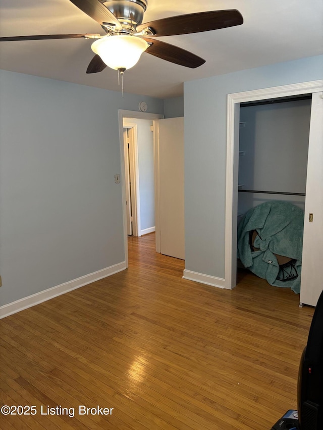 spare room featuring a ceiling fan, baseboards, and wood finished floors