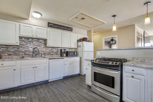 kitchen with backsplash, appliances with stainless steel finishes, dark wood-type flooring, white cabinets, and a sink