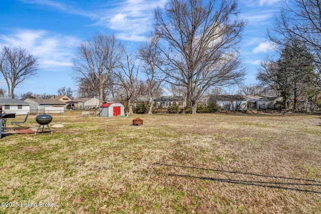 view of yard featuring a shed, an outdoor structure, and fence