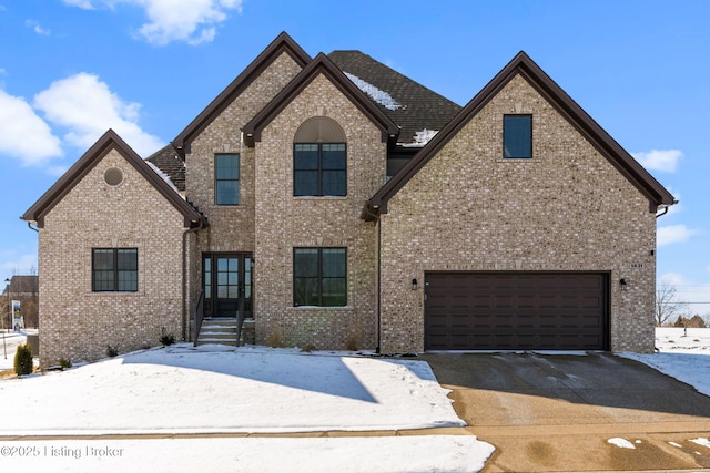 view of front facade featuring brick siding, driveway, and an attached garage