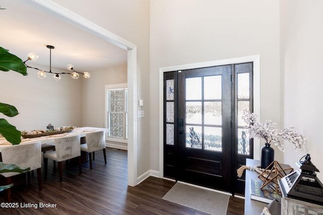 entrance foyer featuring dark wood-style floors, baseboards, and a chandelier