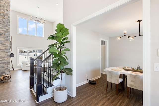 interior space featuring a chandelier, stairway, dark wood-style flooring, and baseboards