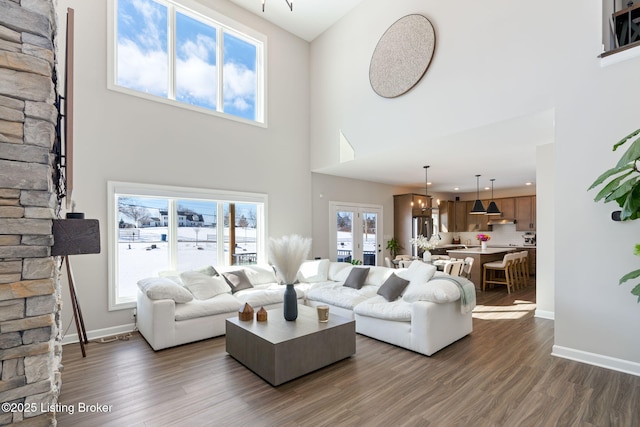 living room featuring dark wood-style floors, a high ceiling, and baseboards