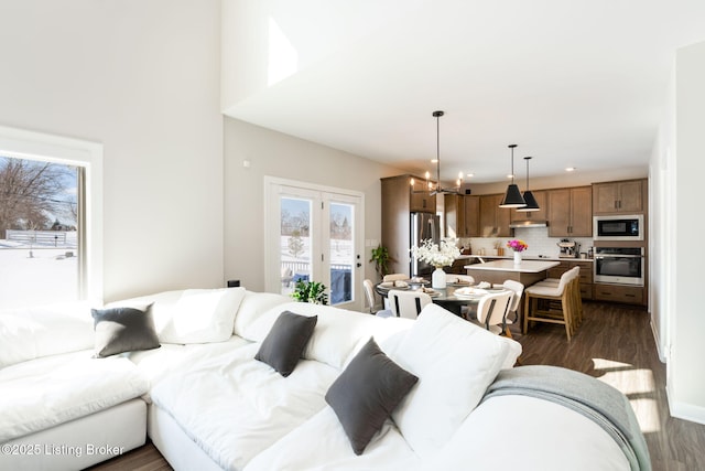 living area with dark wood-style floors and an inviting chandelier