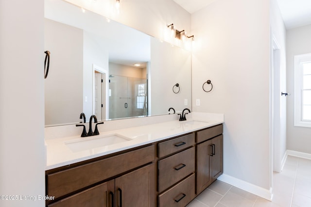 full bath with double vanity, a stall shower, tile patterned flooring, and a sink