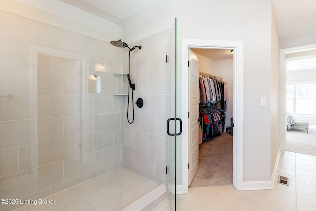 full bath featuring visible vents, a spacious closet, a shower stall, tile patterned flooring, and baseboards