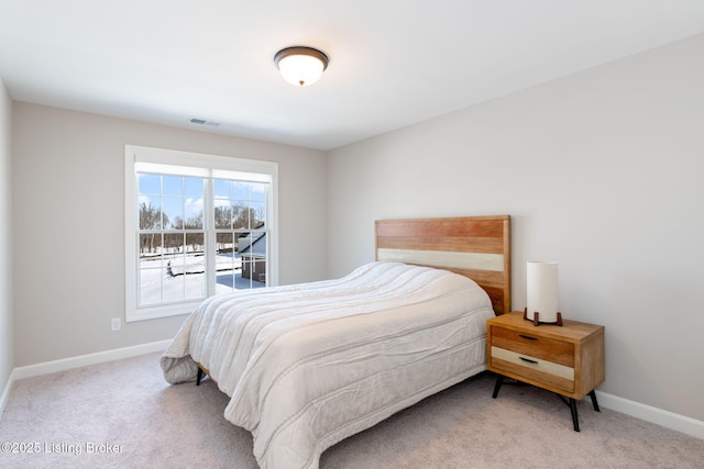 bedroom with light colored carpet, visible vents, and baseboards