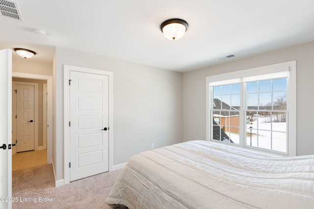 bedroom featuring visible vents, light carpet, and baseboards