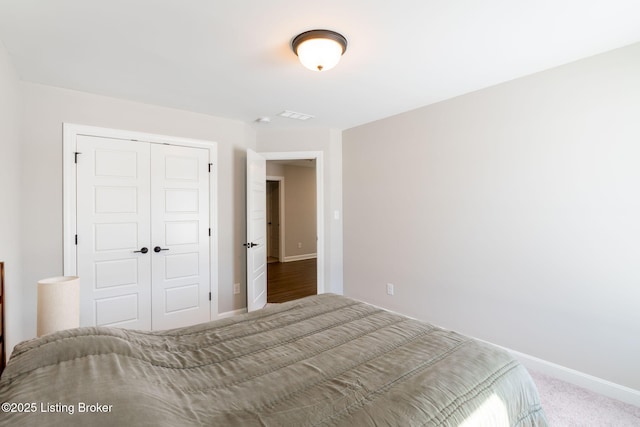 bedroom with carpet, a closet, visible vents, and baseboards