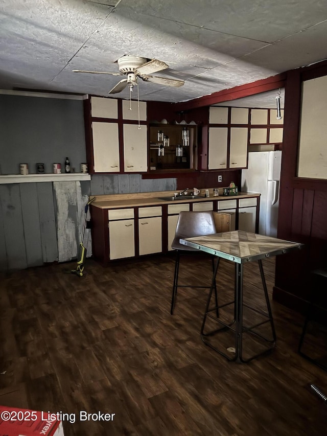 kitchen with ceiling fan, a sink, wood finished floors, light countertops, and freestanding refrigerator