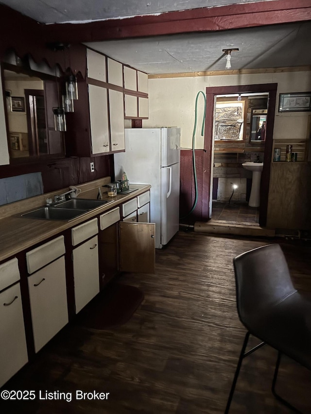 kitchen with dark wood-style floors, a sink, and white cabinetry