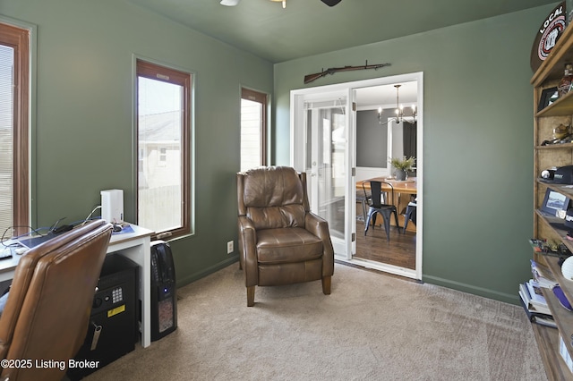 living area featuring light carpet, a notable chandelier, and baseboards