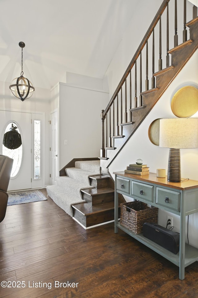 entryway with dark wood-style floors, stairway, and a chandelier