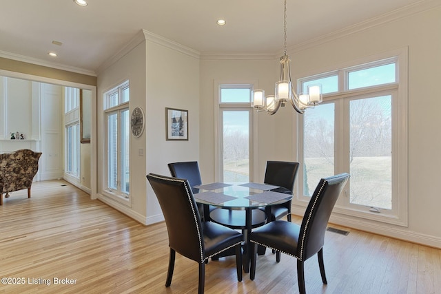 dining space with light wood finished floors, a notable chandelier, baseboards, and crown molding