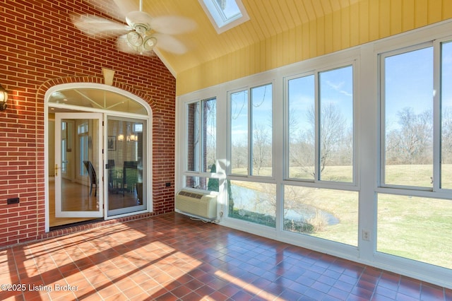 unfurnished sunroom with vaulted ceiling with skylight, plenty of natural light, cooling unit, and a ceiling fan