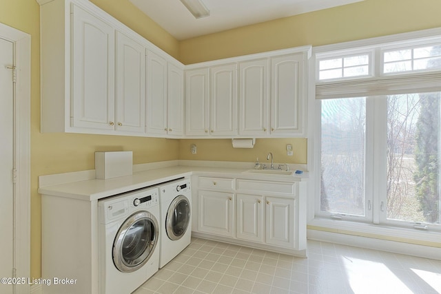 clothes washing area featuring cabinet space, a sink, washer and clothes dryer, and light tile patterned floors