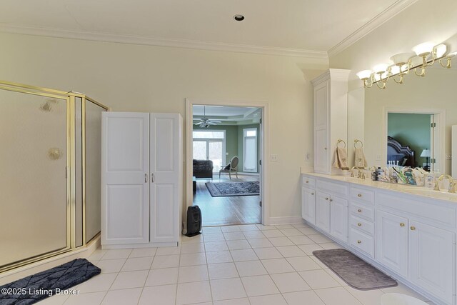 full bath with double vanity, ornamental molding, a sink, ensuite bath, and tile patterned flooring