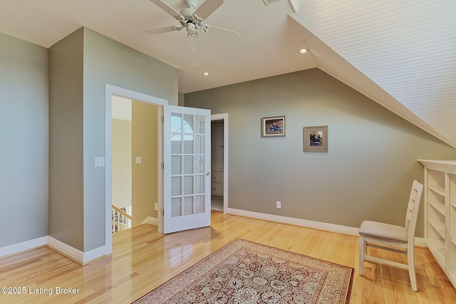 sitting room with baseboards, vaulted ceiling, wood finished floors, and an upstairs landing