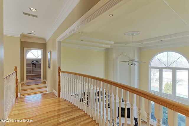 hall featuring visible vents, light wood-style flooring, ornamental molding, an upstairs landing, and recessed lighting