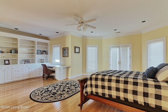 bedroom with ornamental molding, light wood finished floors, multiple windows, and built in study area