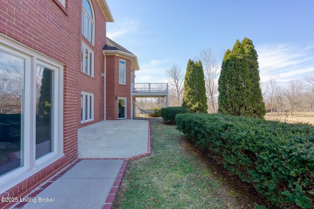 view of yard featuring a patio and a balcony