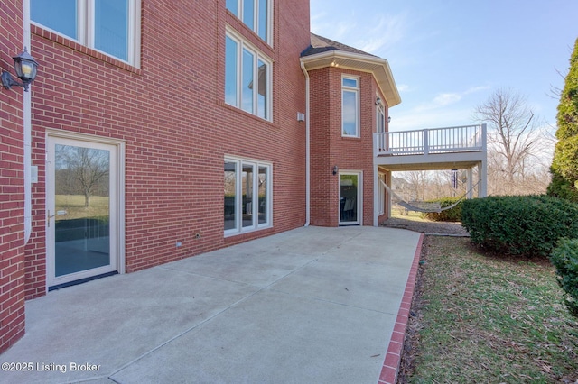 back of property with brick siding and a patio