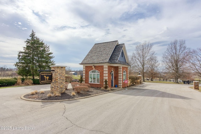 view of side of property featuring driveway and brick siding