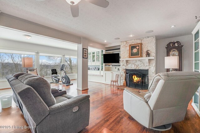 950 Lakeview Dr, Bloomfield, KY 40008 - living area featuring a ceiling fan, wood finished floors, a fireplace, and a textured ceiling