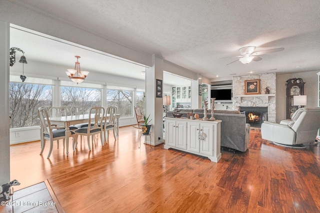 950 Lakeview Dr, Bloomfield, KY 40008 - interior space featuring a stone fireplace, wood finished floors, a ceiling fan, and a textured ceiling