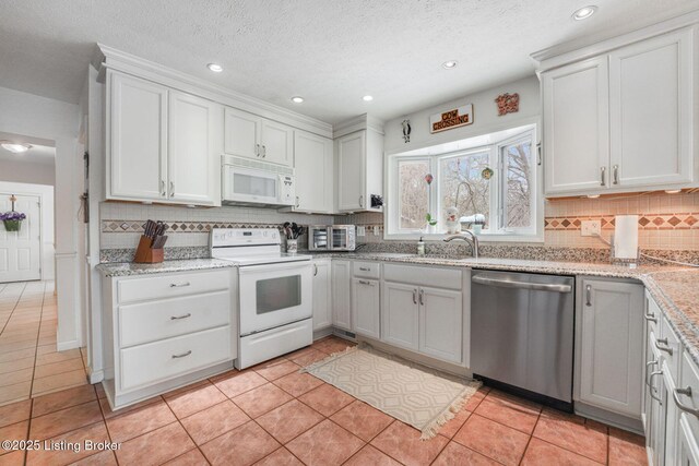 950 Lakeview Dr, Bloomfield, KY 40008 - kitchen featuring light tile patterned floors, white appliances, backsplash, and a textured ceiling