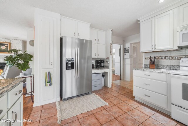 950 Lakeview Dr, Bloomfield, KY 40008 - kitchen featuring light stone counters, backsplash, white appliances, white cabinets, and light tile patterned flooring