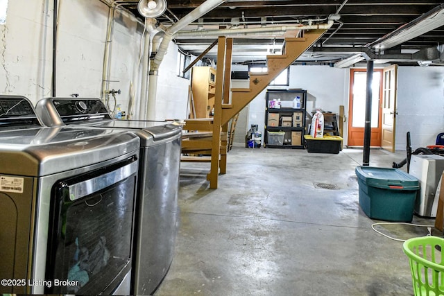 below grade area featuring washing machine and clothes dryer and stairs