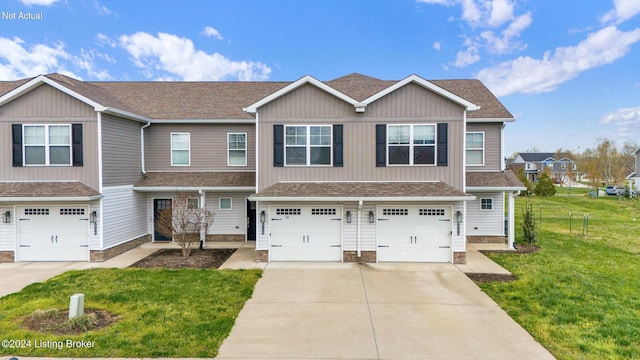 townhome / multi-family property with a garage, concrete driveway, a shingled roof, and a front yard