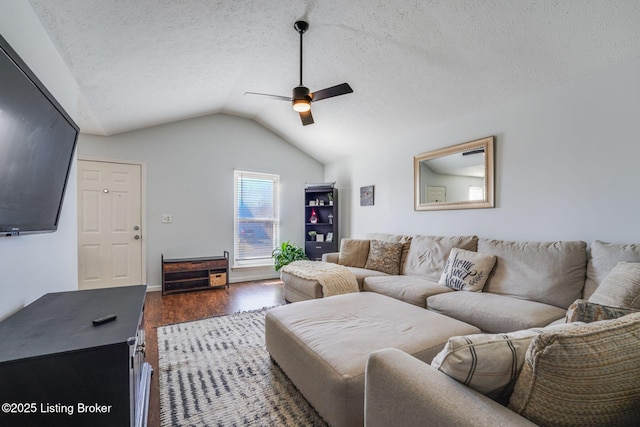 living room featuring lofted ceiling, dark wood-style floors, a ceiling fan, and a textured ceiling