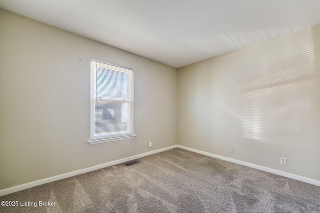 carpeted empty room featuring visible vents and baseboards