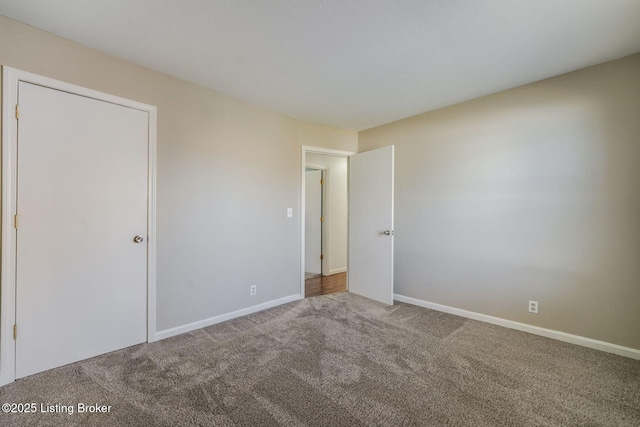 unfurnished bedroom with carpet floors and baseboards