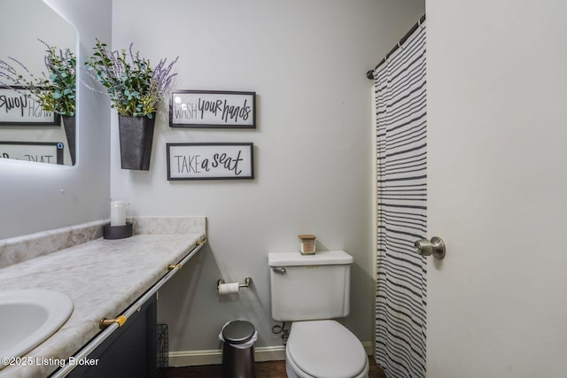 full bath with vanity, toilet, and baseboards