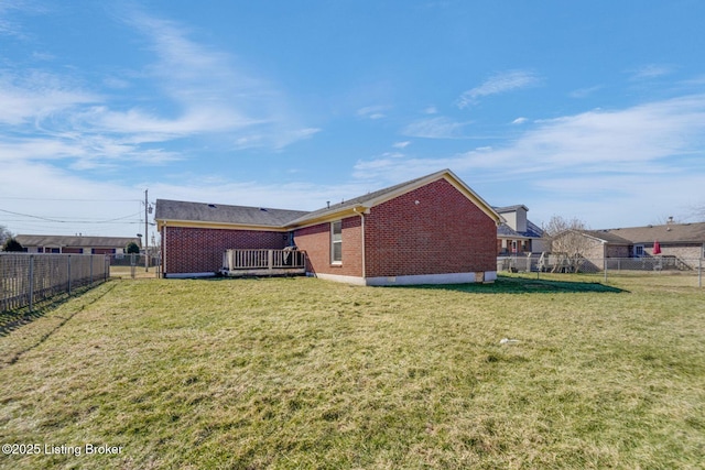 rear view of house featuring a yard, a fenced backyard, and brick siding