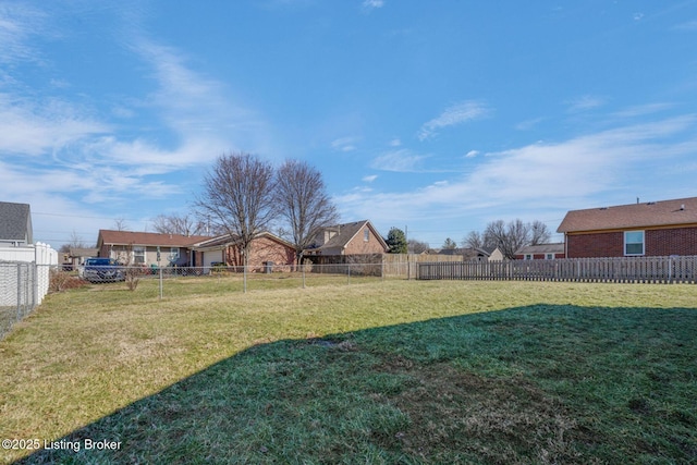 view of yard with a fenced backyard and a residential view